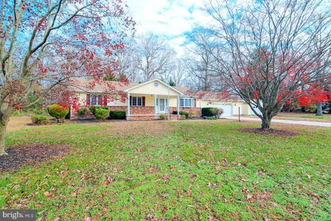 an aerial view of a house with a yard and a large tree