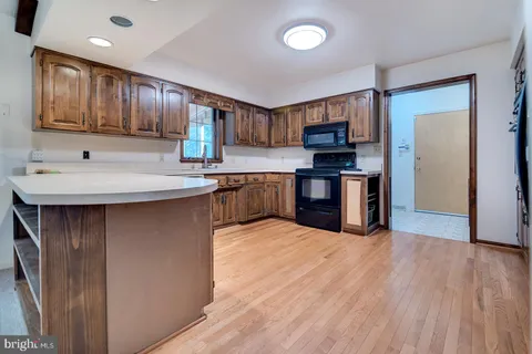 a kitchen with granite countertop a stove a sink and a microwave