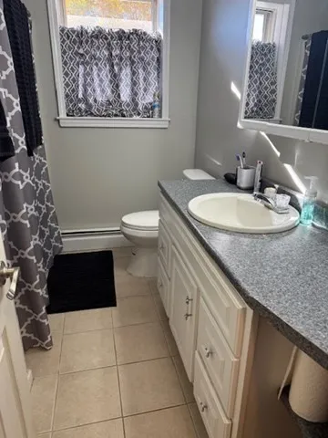 a bathroom with a granite countertop sink a toilet and a mirror