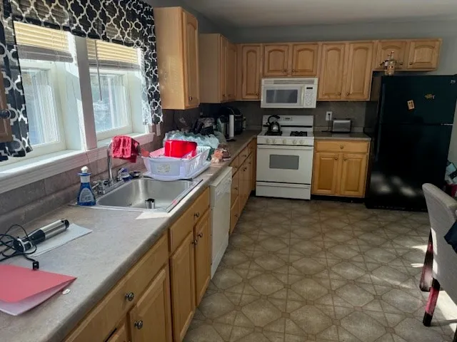a kitchen with kitchen island granite countertop a stove sink and cabinets
