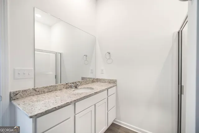 a bathroom with a granite countertop sink and a mirror