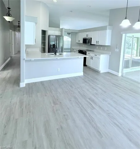 a kitchen with kitchen island granite countertop wooden floors and stainless steel appliances