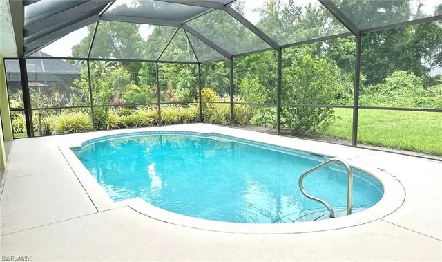a view of a swimming pool with a yard from a porch