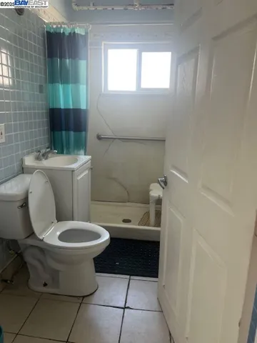 a bathroom with a granite countertop toilet and a sink