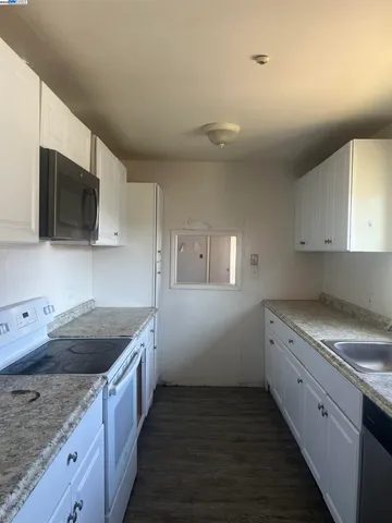 a kitchen with granite countertop sink stainless steel appliances and cabinets