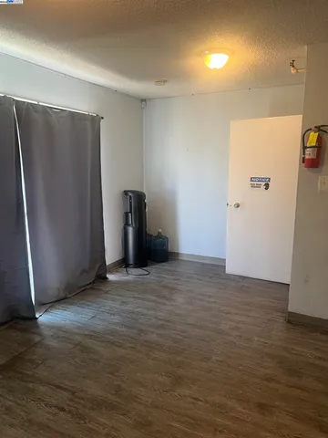 a view of an empty room with closet and a window