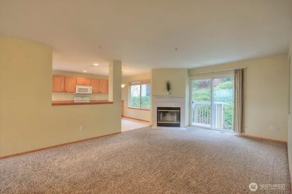 a view of an empty room with a fireplace and a window