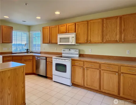 a kitchen with white cabinets sink and white appliances