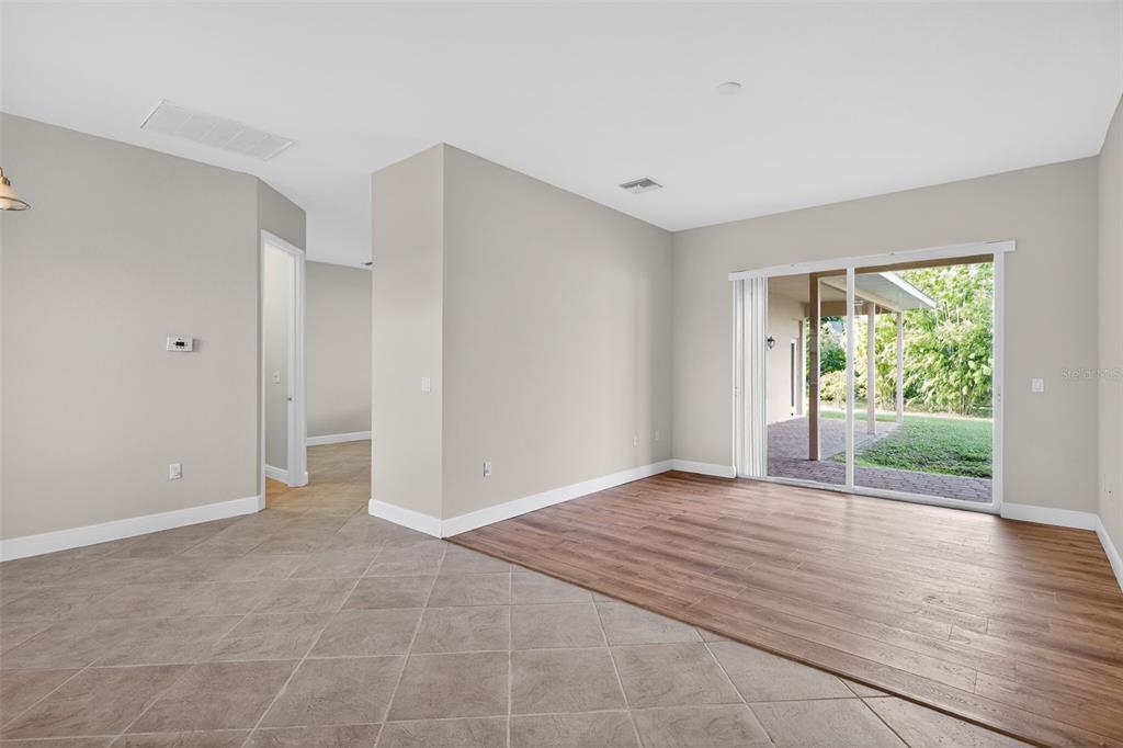 1216 Heavitree Court Sebring, FL 33876 - Photo 12 of 35 a view of an empty room with wooden floor and a window
