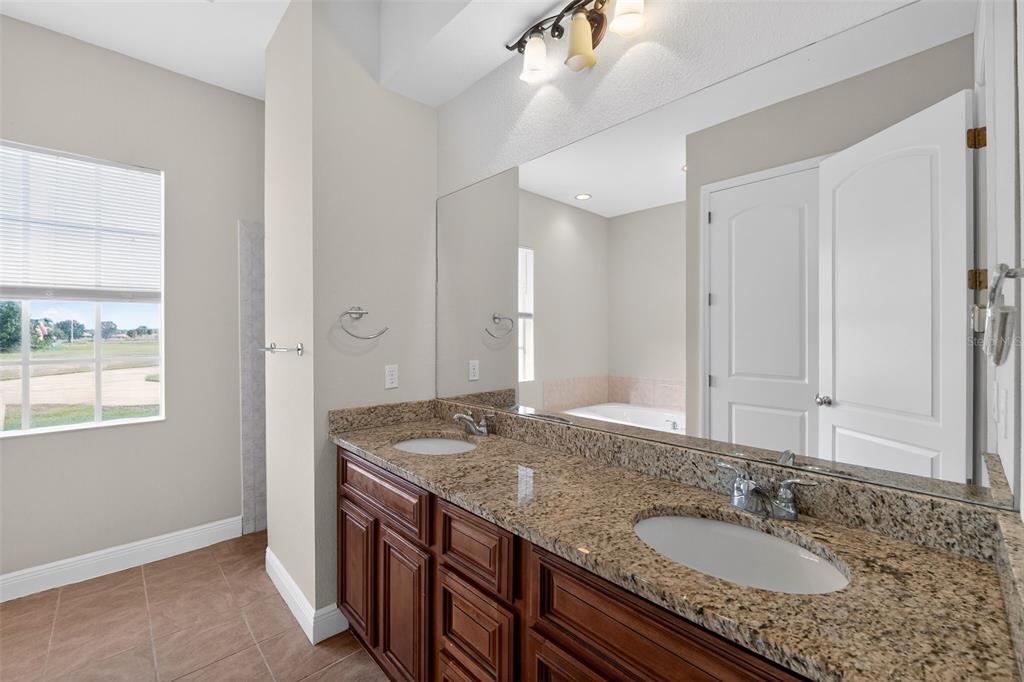 1216 Heavitree Court Sebring, FL 33876 - Photo 14 of 35 a bathroom with a granite countertop sink and a mirror