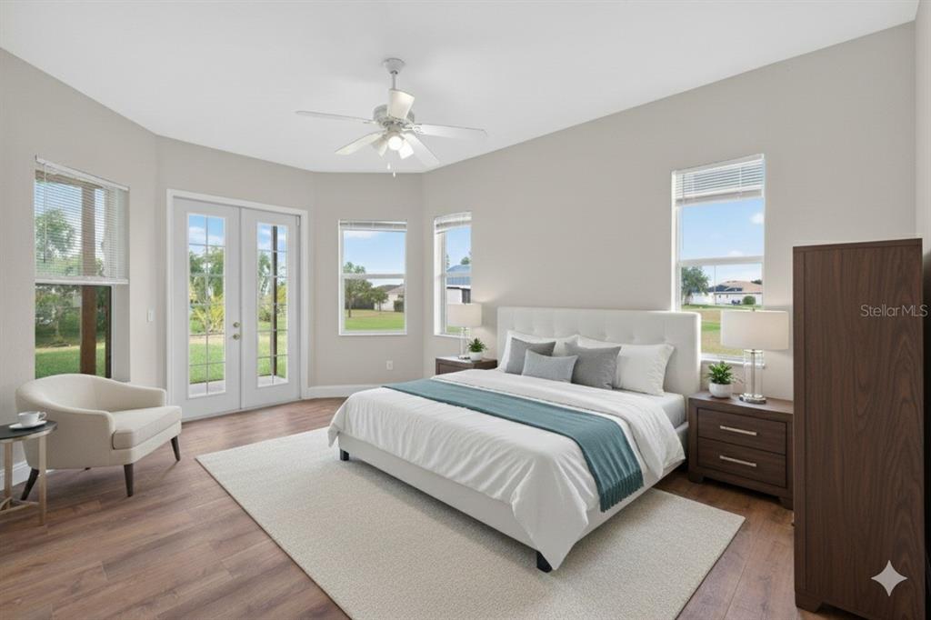 1216 Heavitree Court Sebring, FL 33876 - Photo 15 of 35 a bedroom with a large bed and a chandelier