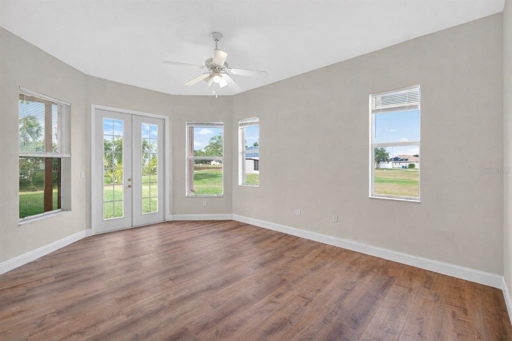 1216 Heavitree Court Sebring, FL 33876 - Photo 16 of 35 a view of an empty room with wooden floor and a window