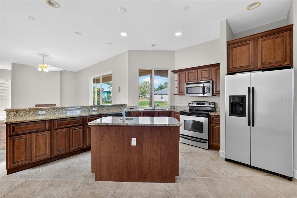 1216 Heavitree Court Sebring, FL 33876 - Photo 2 of 35 a kitchen with kitchen island a sink stove and refrigerator