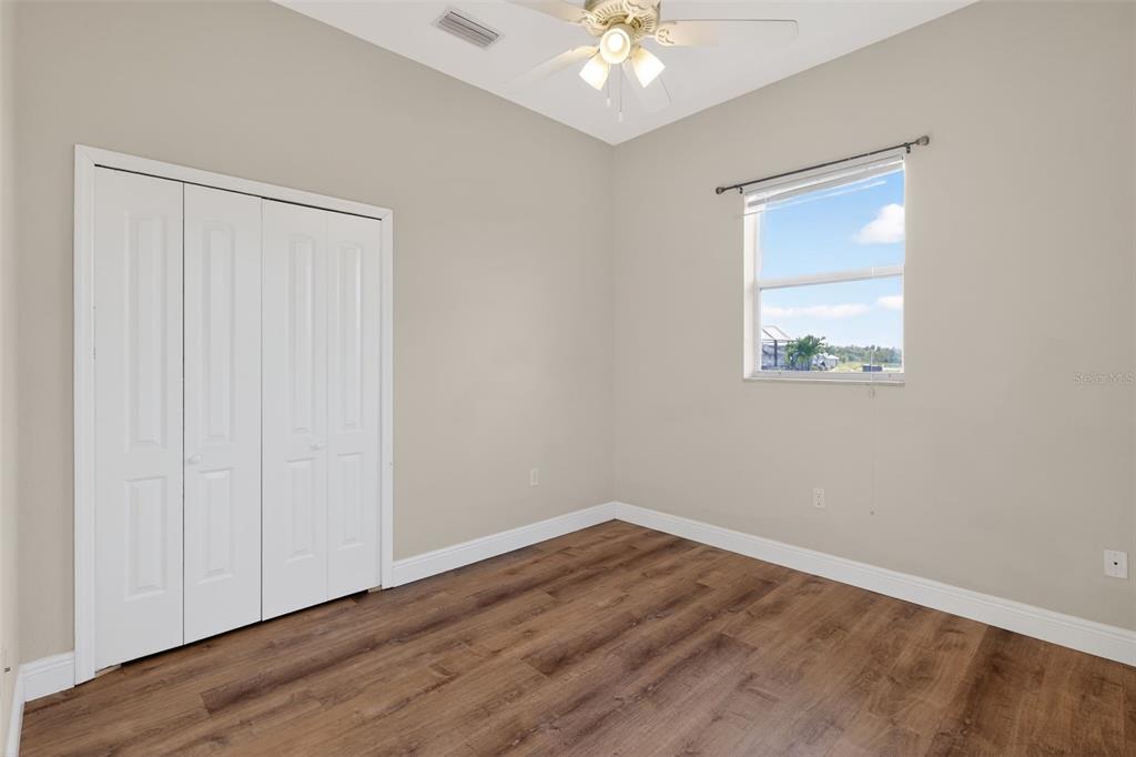 1216 Heavitree Court Sebring, FL 33876 - Photo 23 of 35 a view of an empty room with wooden floor and a window