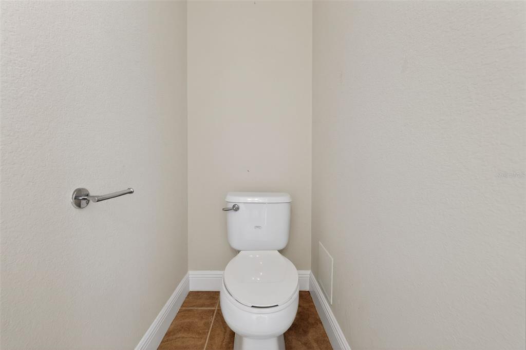 1216 Heavitree Court Sebring, FL 33876 - Photo 24 of 35 a white toilet sitting in a bathroom next to a wooden wall