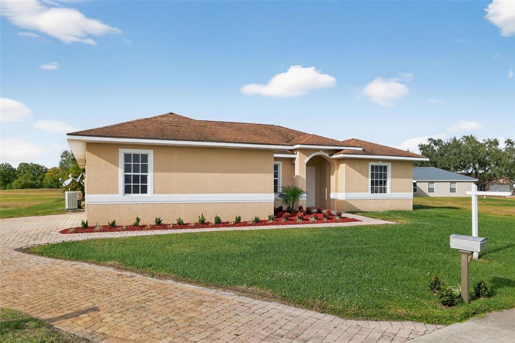 1216 Heavitree Court Sebring, FL 33876 - Photo 30 of 35 a front view of a house with a garden and yard