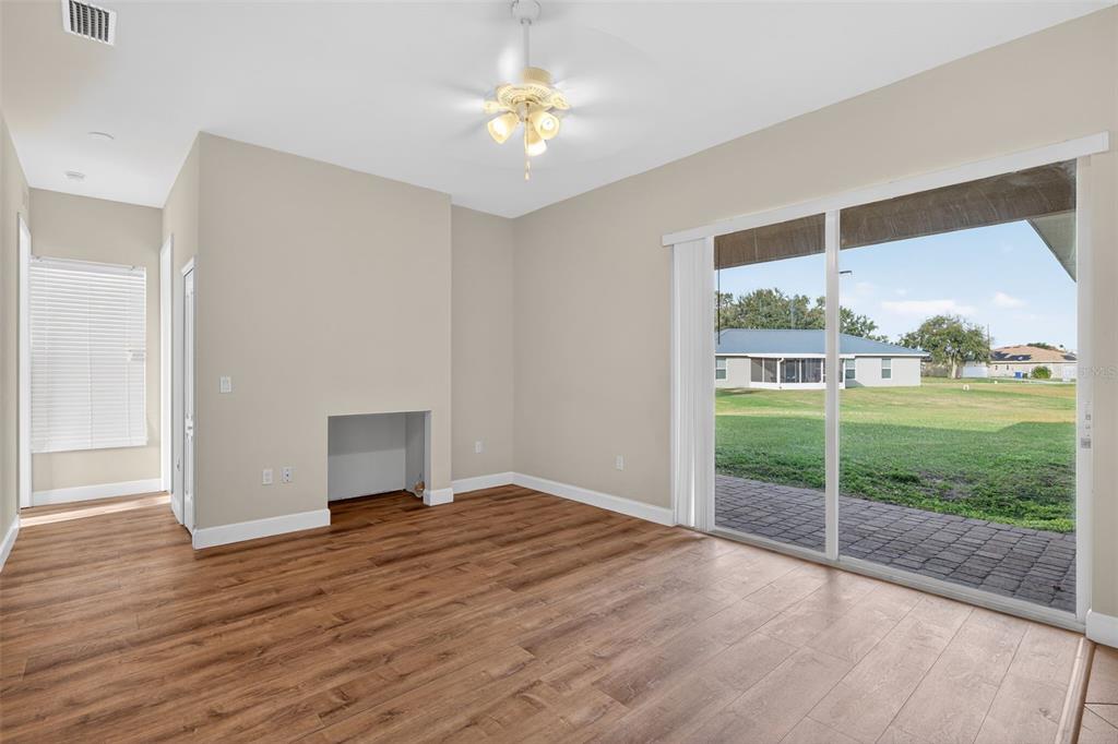 1216 Heavitree Court Sebring, FL 33876 - Photo 3 of 35 a view of a room with wooden floor and a fireplace