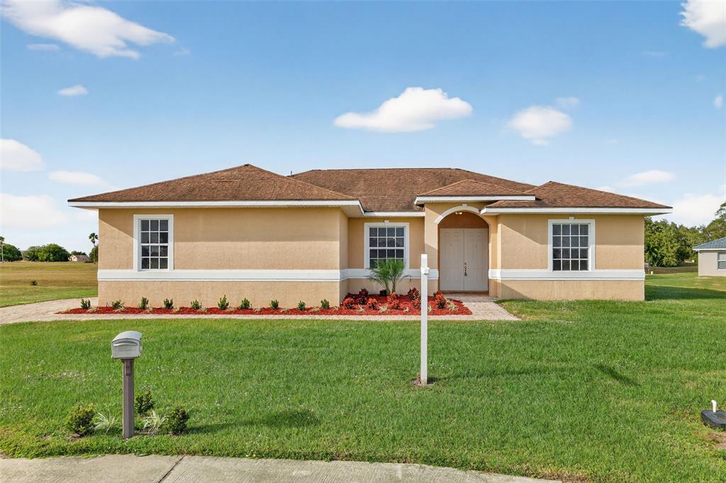 1216 Heavitree Court Sebring, FL 33876 - Photo 32 of 35 a front view of a house with a garden and yard