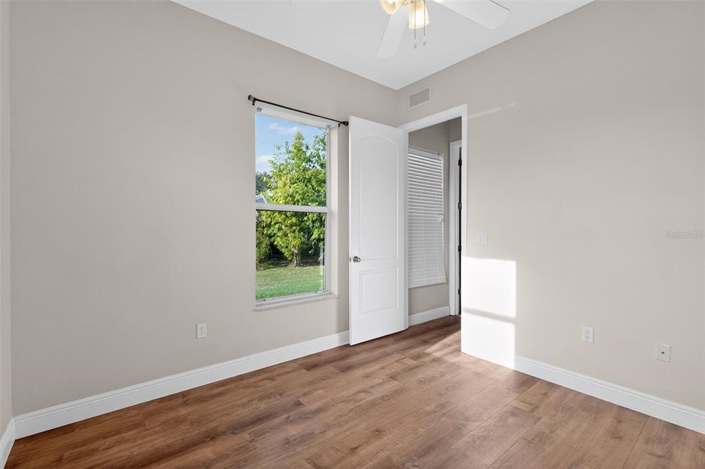 1216 Heavitree Court Sebring, FL 33876 - Photo 10 of 35 an empty room with wooden floor and windows
