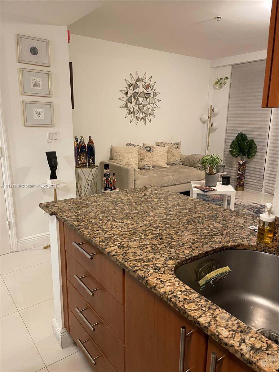 2701 Southwest 3rd Avenue, Unit 202 Miami, FL 33129 - Photo 4 of 26 a kitchen with kitchen island granite countertop a sink and a stove