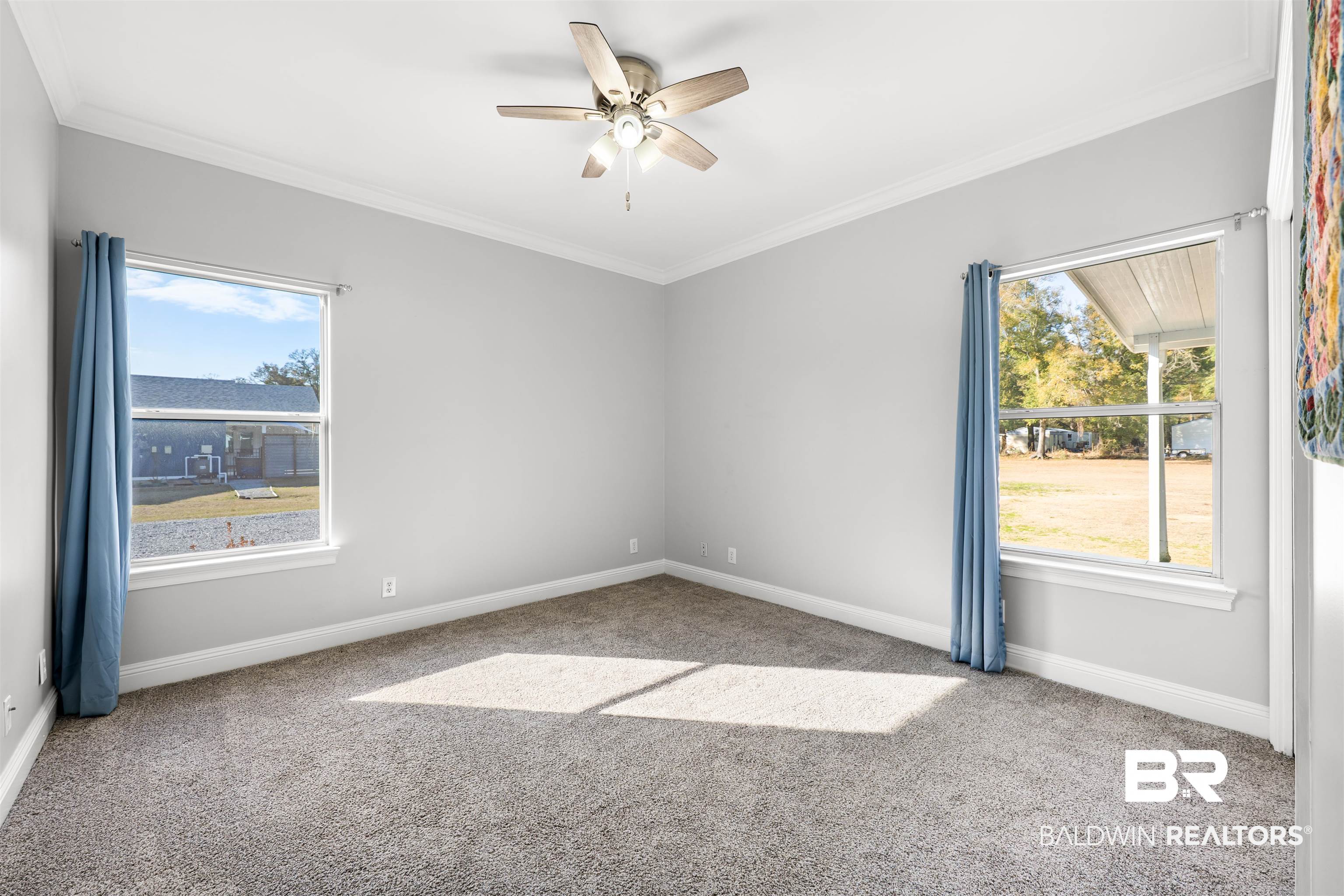 19079 Baldwin County Road 10 Foley, AL 36535 - Photo 14 of 37 Spare room featuring crown molding, ceiling fan, and light colored carpet