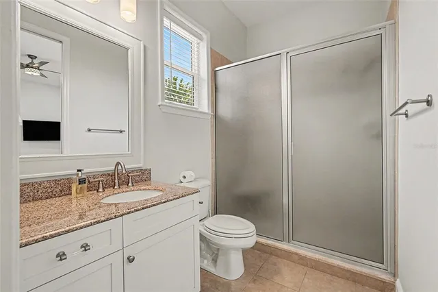 a bathroom with a granite countertop sink toilet and shower
