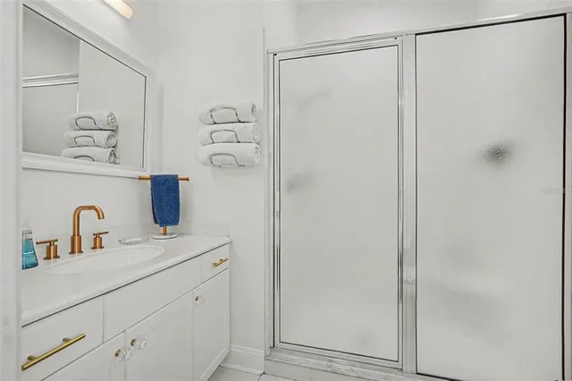 a bathroom with a shower sink and mirror
