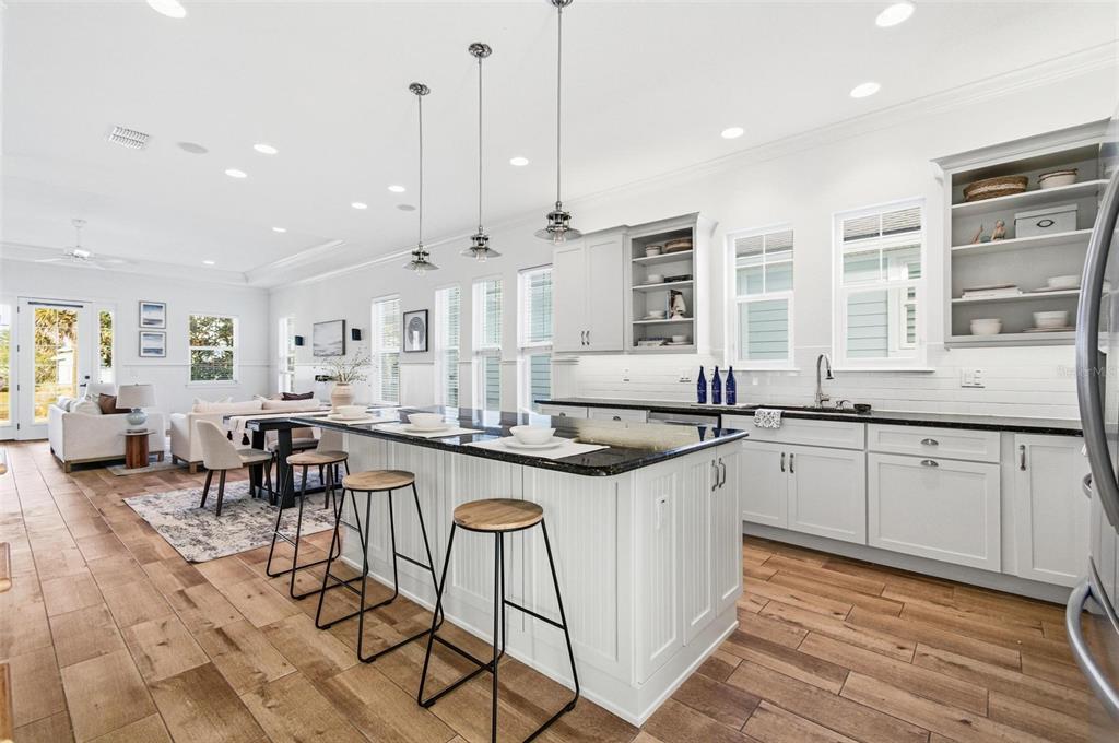 25 Sandy Beach Way Palm Coast, FL 32137 - Photo 13 of 41 an open kitchen with granite countertop a stove a sink a dining table and chairs with wooden floor