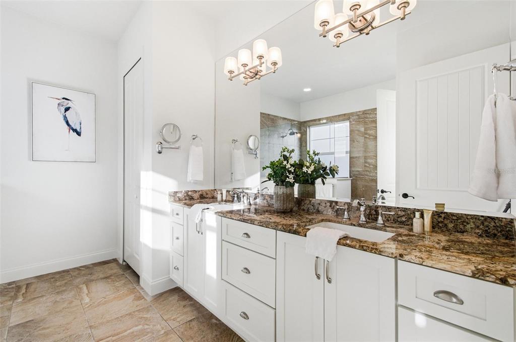 25 Sandy Beach Way Palm Coast, FL 32137 - Photo 18 of 41 a bathroom with a granite countertop sink a large mirror and a shower