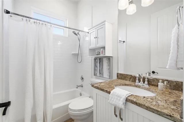 a kitchen with granite countertop a sink cabinets and wooden floor