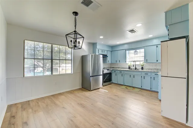 a kitchen with kitchen island cabinets and refrigerator