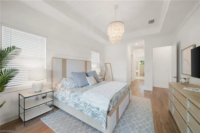 a bedroom with a bed window and a flat screen tv