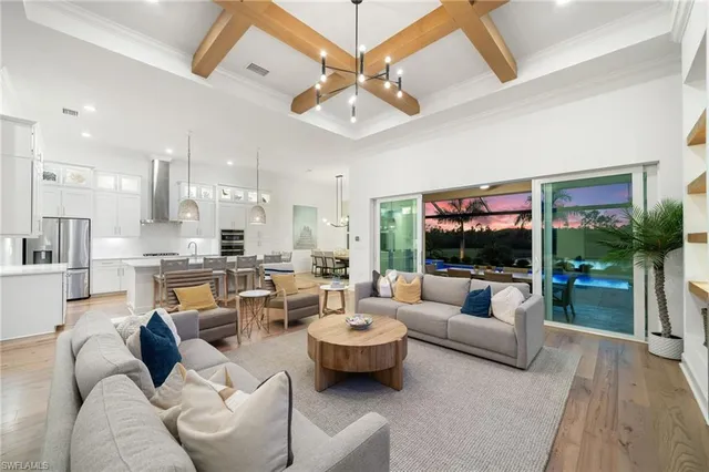 a living room with furniture a chandelier and a flat screen tv