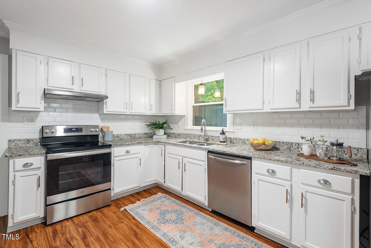4102 Trotter Ridge Road Durham, NC 27707 - Photo 14 of 41 a kitchen with stainless steel appliances granite countertop a stove and white cabinets