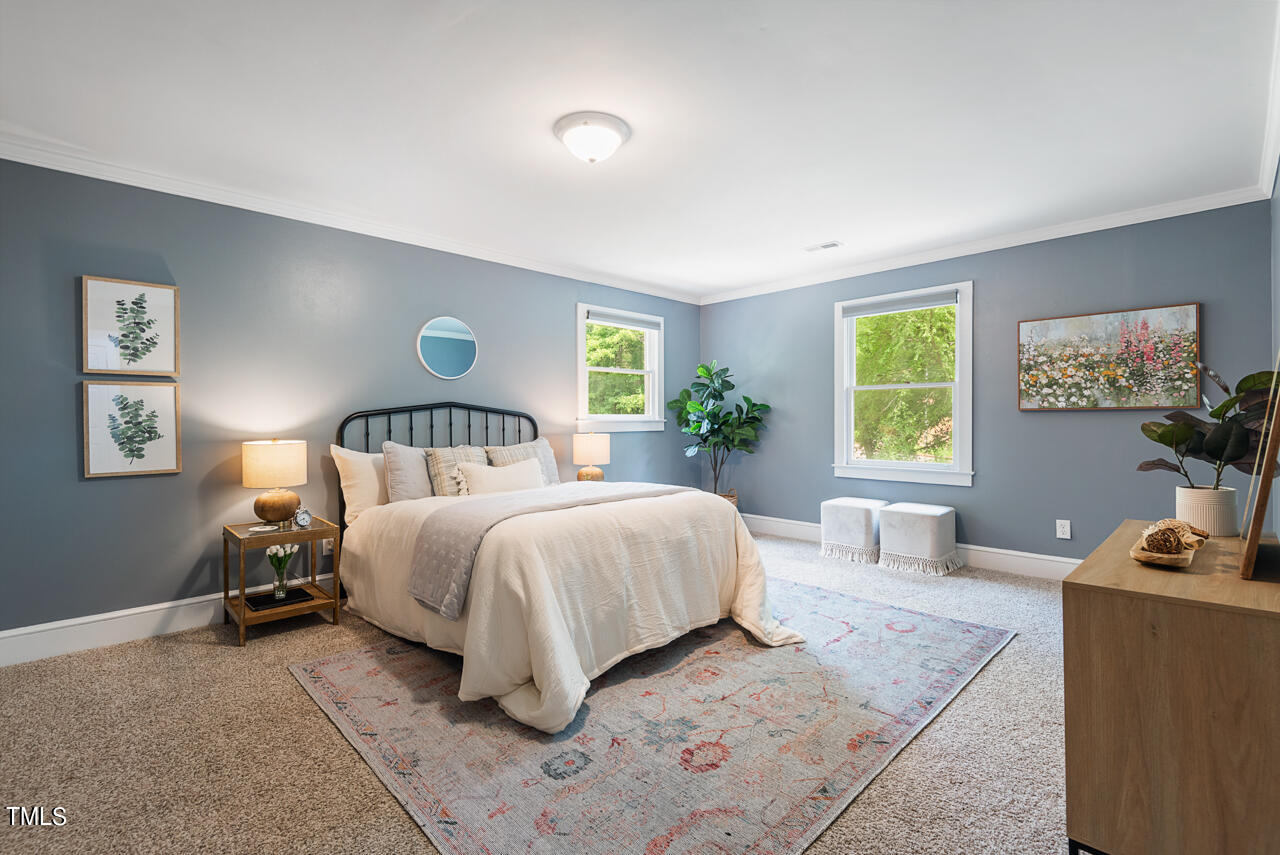 4102 Trotter Ridge Road Durham, NC 27707 - Photo 19 of 41 a spacious bedroom with a bed a couch and a flat tv screen on the dresser