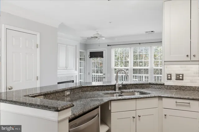 a kitchen with granite countertop sink and window