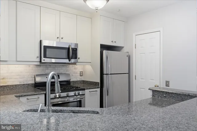 a kitchen with stainless steel appliances a refrigerator sink and microwave
