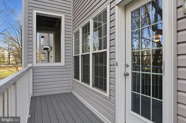 a view of a balcony with wooden floor and windows