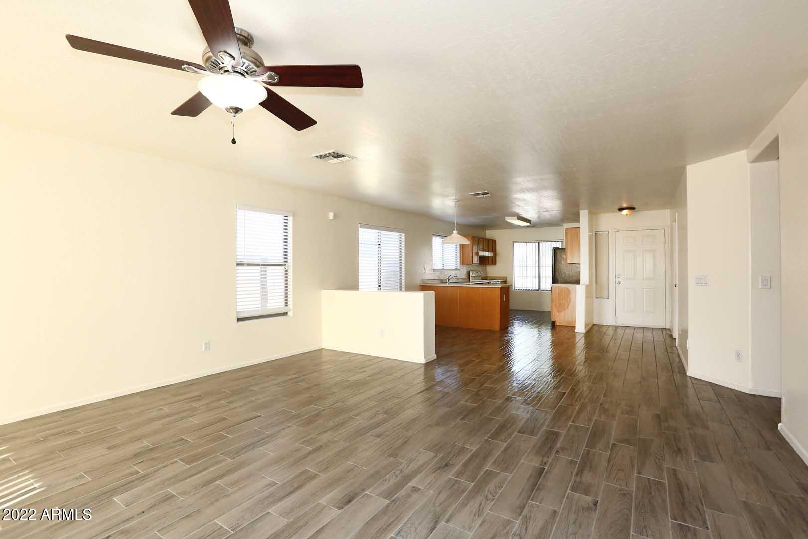 4319 West Carson Road Laveen, AZ 85339 - Photo 11 of 36 a view of a kitchen with wooden floor a ceiling fan and windows