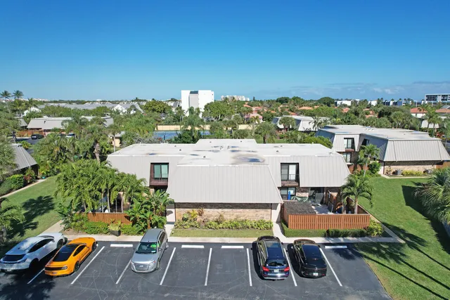 an aerial view of a residential apartment building with a yard and lake view