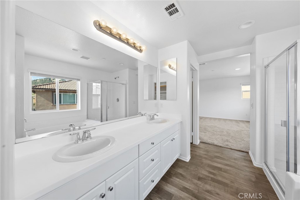 259 Spotted Saddle Way Fallbrook, CA 92028 - Photo 17 of 43 a bathroom with a double vanity sink a mirror and a shower