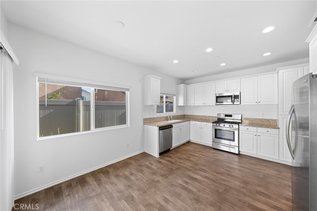 259 Spotted Saddle Way Fallbrook, CA 92028 - Photo 8 of 43 a large kitchen with cabinets wooden floor and stainless steel appliances