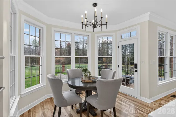 a dining room with furniture a livingroom view and wooden floor