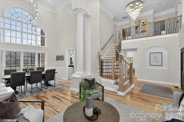a living room with furniture a chandelier and a large mirror