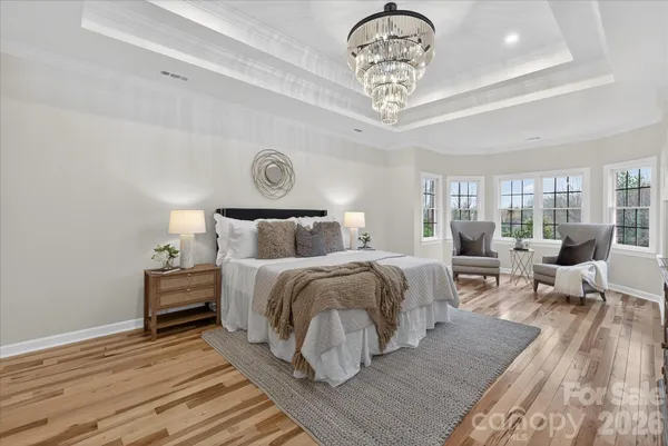 a bedroom with bed and a chandelier