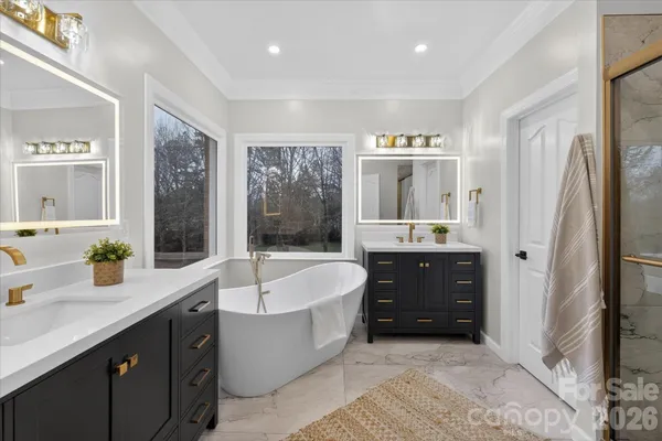 a spacious bathroom with a tub sink and mirror