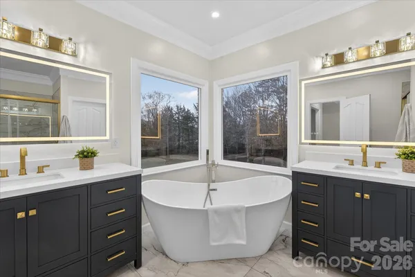 a spacious bathroom with a tub sink and mirror