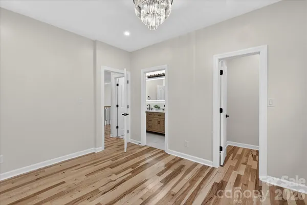 a view of a room with wooden floor and a bathroom