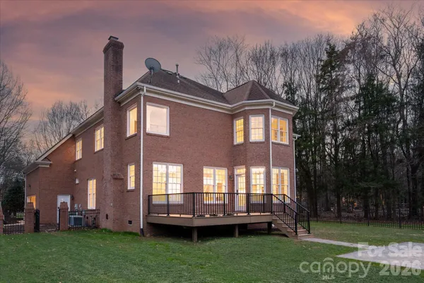 a front view of a house with garden and trees
