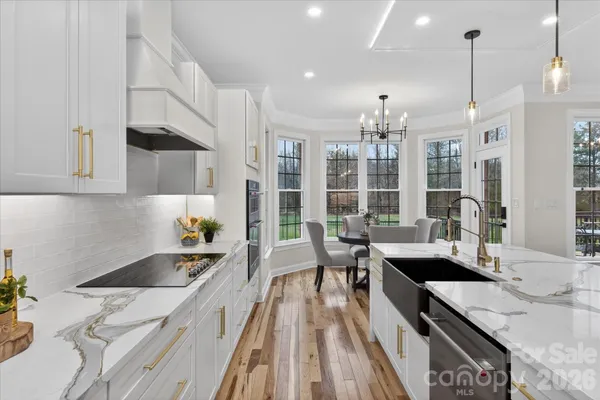 a kitchen with a sink stove and wooden floor